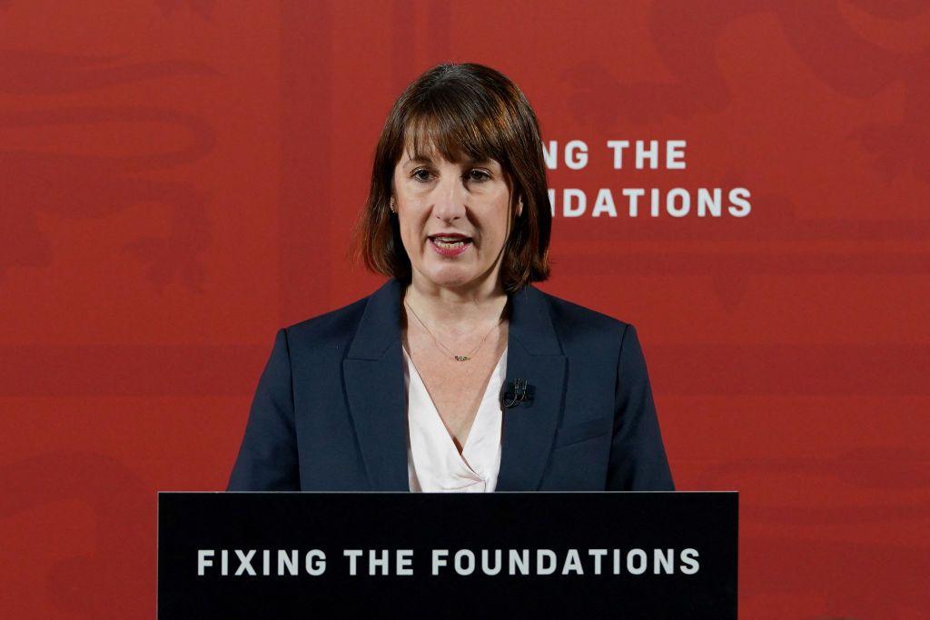 Rachel Reeves stands behind a lectern with the words "fixing the foundations" printed on it