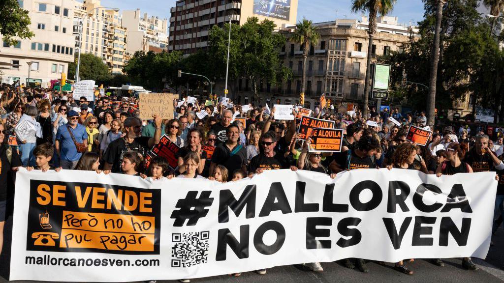 Protesters hold a banner reading "Mallorca is not for sale" during a demonstration to protest against the massification of tourism and housing prices on the island of Mallorca in Palma de Mallorca 