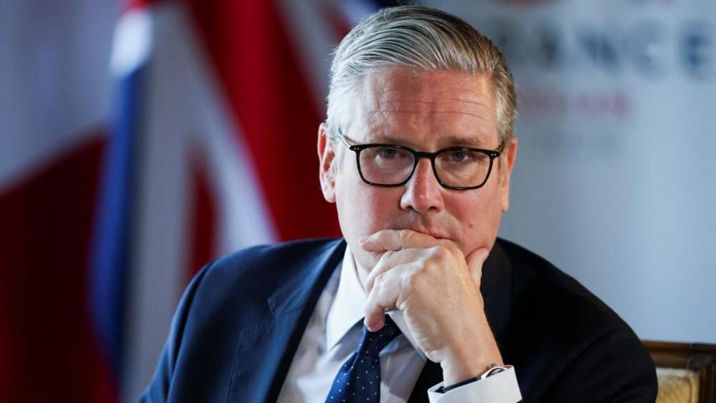 Starmer rests his chin on his left hand