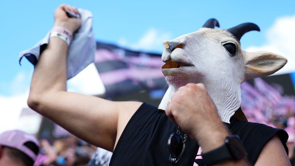 A fan wearing a fake goat head mask