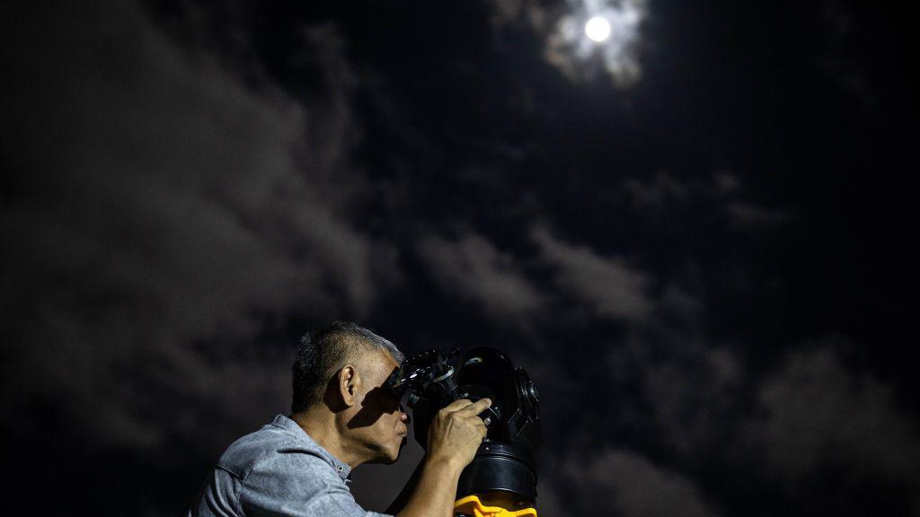 A man sets up a telescope in Indonesia