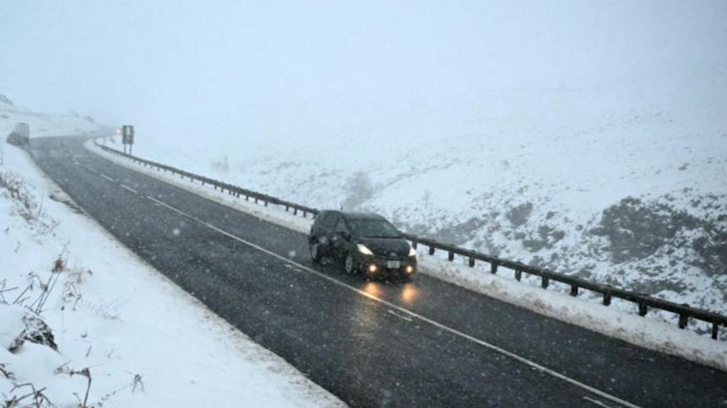 A car is driven along the snow-covered Woodhead pass between Woodhead and Homlfirth, in the Peak District in northern England on January 7, 2025, 