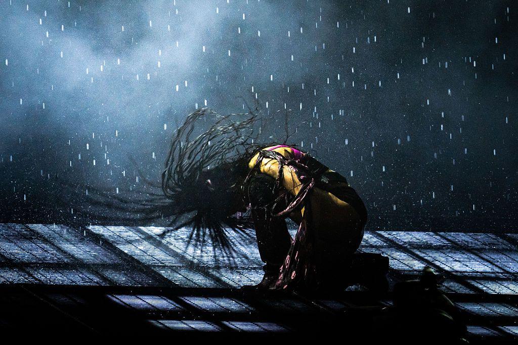 Charli XCX headbangs on stage during her set at the 2025 Glastonbury Festival