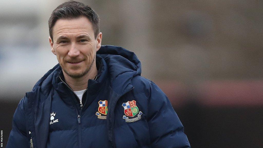 Wealdstone manager Stuart Maynard smiles on the pitch