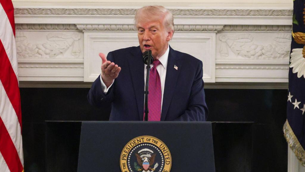 Trump speaking at a lectern in the White House