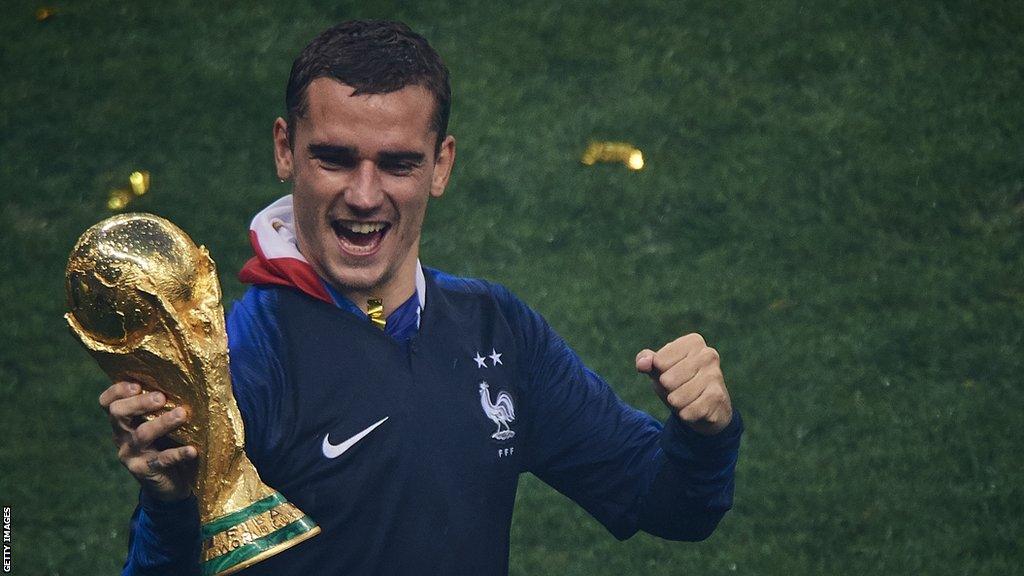 Antoine Griezmann holds the World Cup trophy aloft