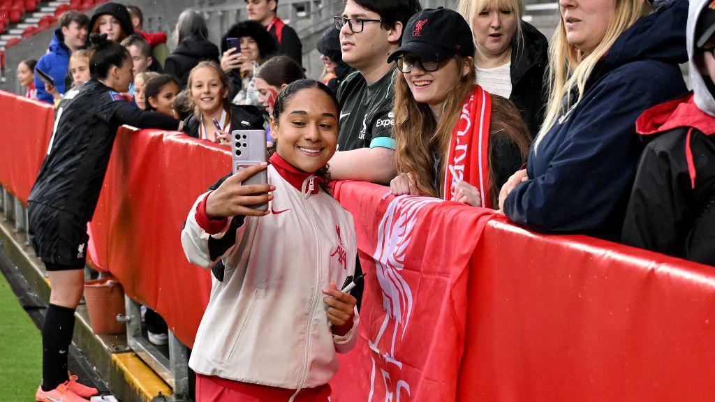 Olivia taking a selfie with a fan.