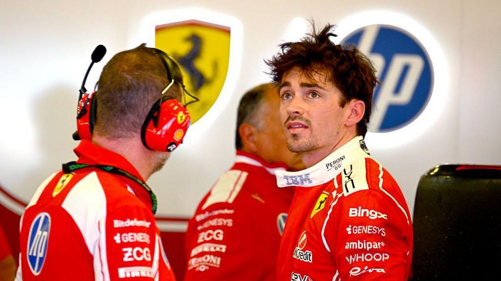 Charles Leclerc stands in the ferrari garage after first practice 