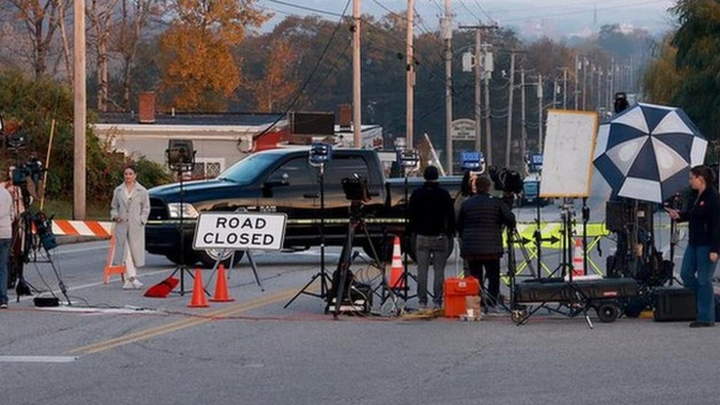 A road is closed as police continue to search for the suspected gunman