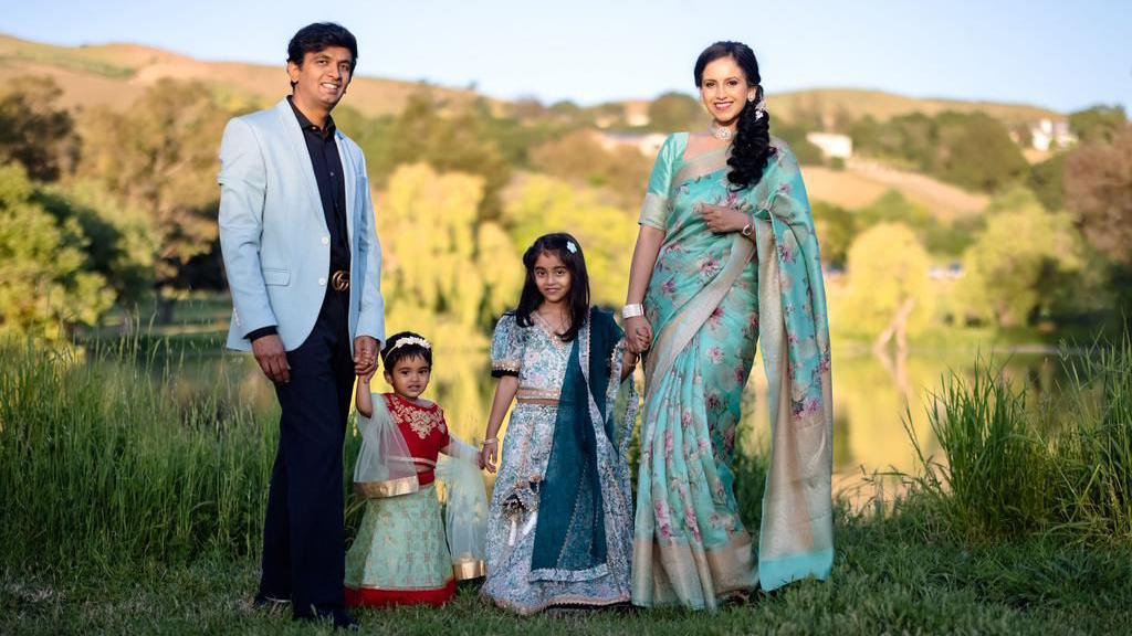 Nithin Hassan wearing a powder blue blazer (L) with his two daughters in the centre and his wife on the right wearing a traditional Indian saree, pose for a photograph. 