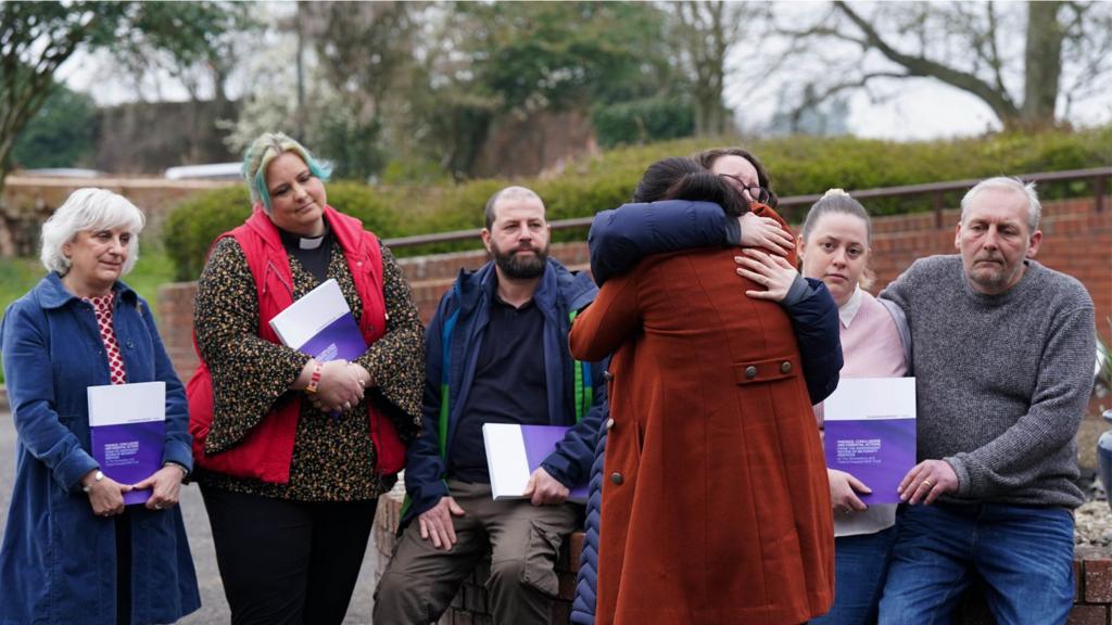 Families together holding copies of Ockenden report