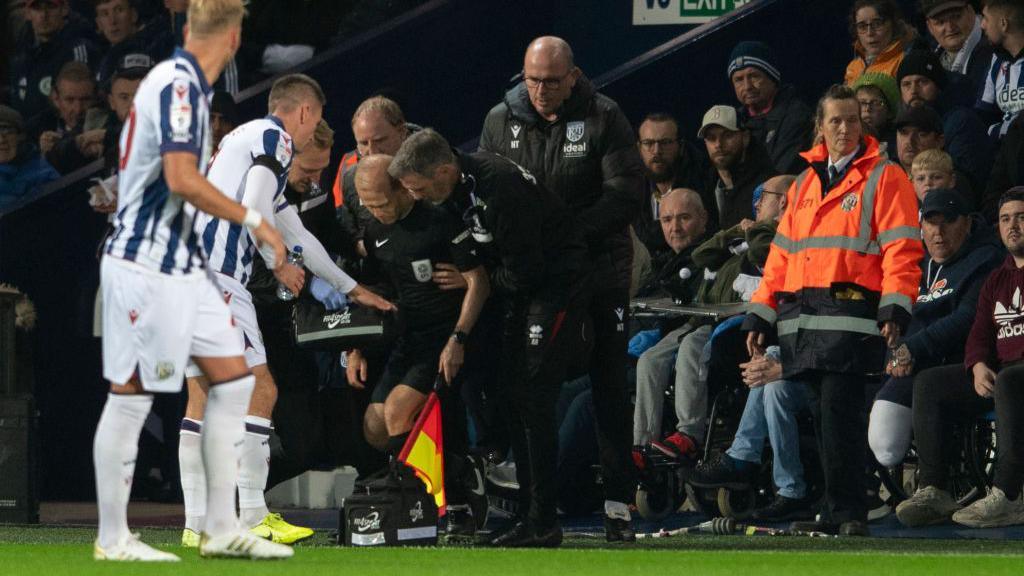 Assistant referee Rob Smith receives treatment after falling ill in a match between West Bromwich Albion and Middlesbrough at The Hawthorns