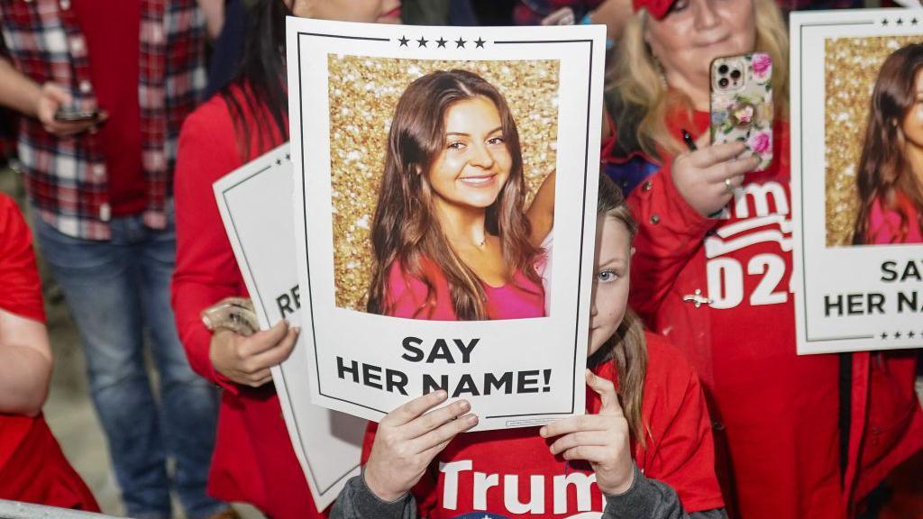 Supporters of former US President and 2024 presidential hopeful Donald Trump hold images of Laken Riley before he speaks at a "Get Out the Vote" rally in Rome, Georgia, on March 9, 2024. 