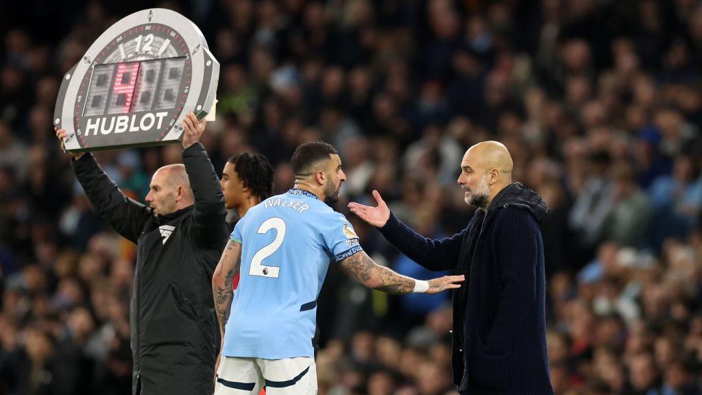 Kyle Walker of Manchester City speaks with Pep Guardiola