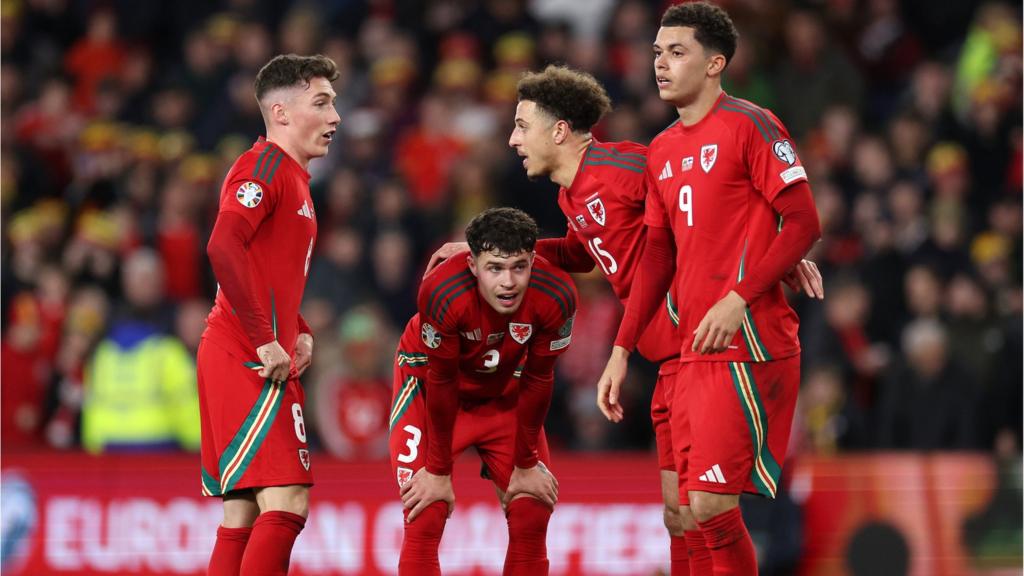 Harry Wilson, Neco Williams, Ethan Ampadu and Brennan Johnson of Wales prepare for a free kick