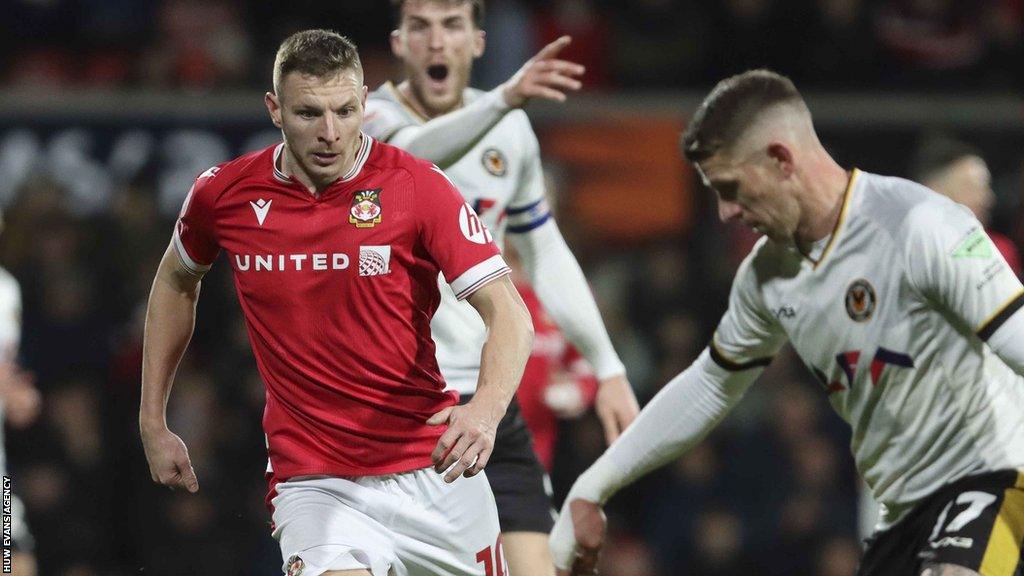 Paul Mullin of Wrexham chases down Newport's Scott Bennett