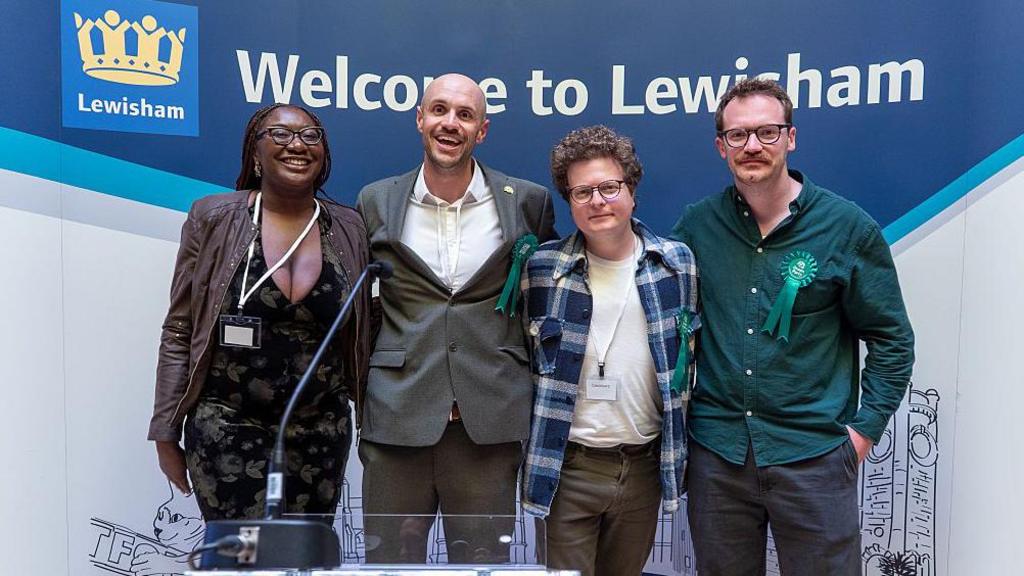 Newly elected Green councillors standing at a lectern smiling