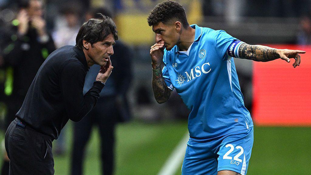 Antonio Conte talks on the touchline to a player