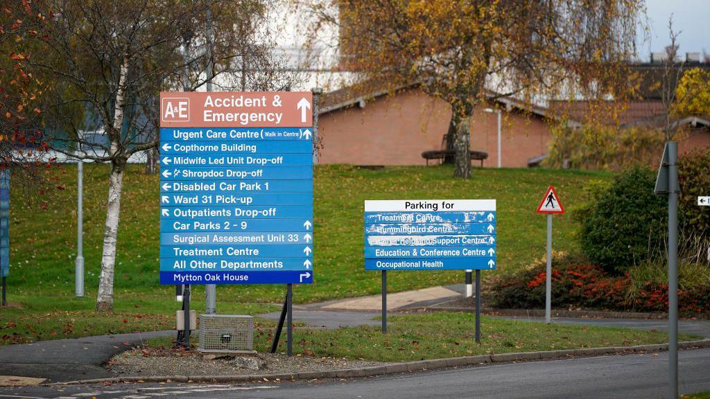 Two signs at the Royal Shrewsbury Hospital. One is for the Accident & Emergency department and the other is for parking. 