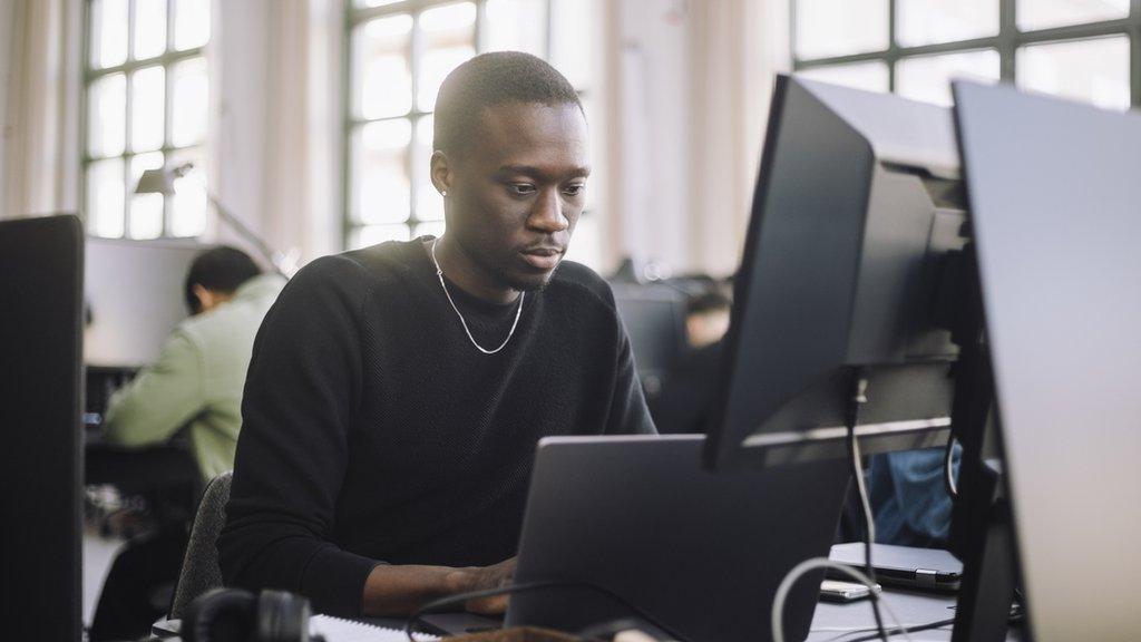 Stock image of a programmer working on a computer in an office