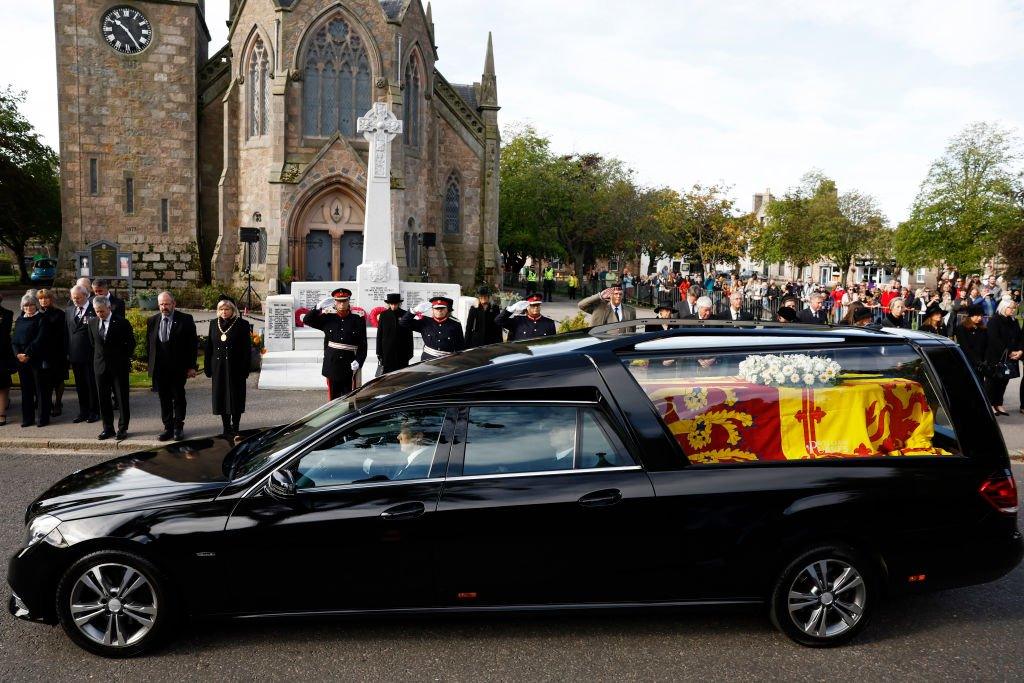 People line the street as the hearse carrying the coffin passes through the village of Ballater, near Balmoral