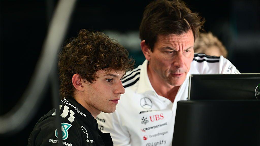 Kimi Antonelli and Mercedes boss Toto Wolff look at a computer screen at Monza