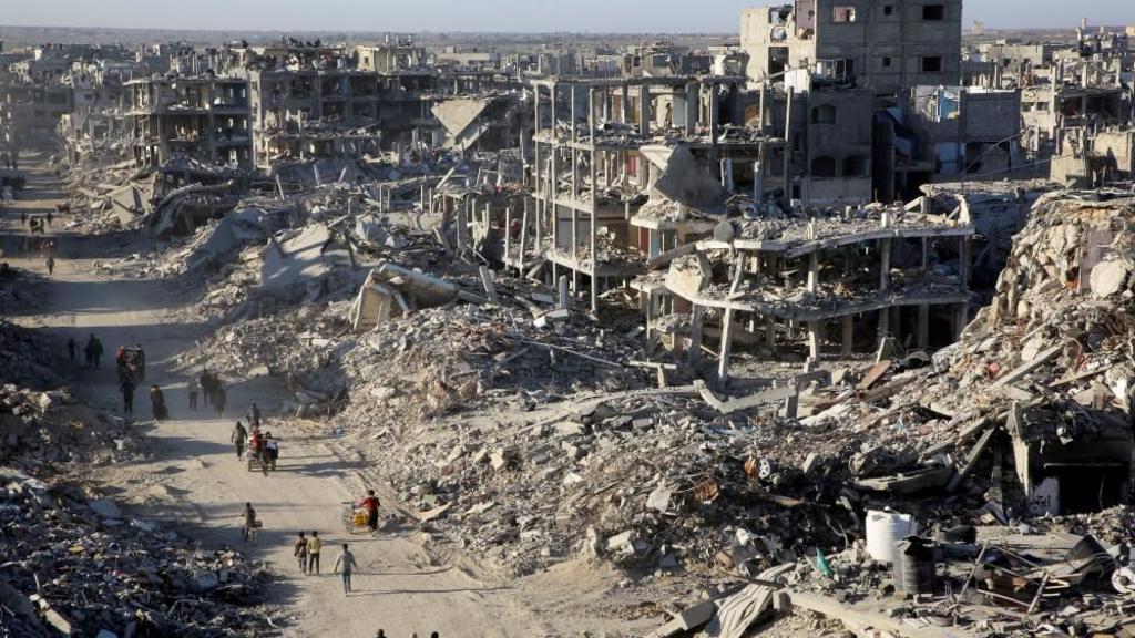 Palestinians walk past the rubble of houses and buildings destroyed during the war, following a ceasefire between Israel and Hamas, in Rafah in the southern Gaza Strip, January 20, 2025