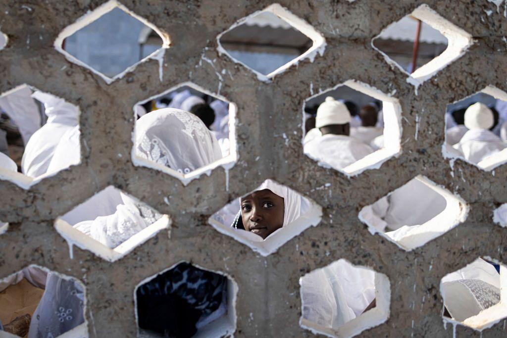 A young follower looks inquisitively through an opening in the brise-soleil wall.