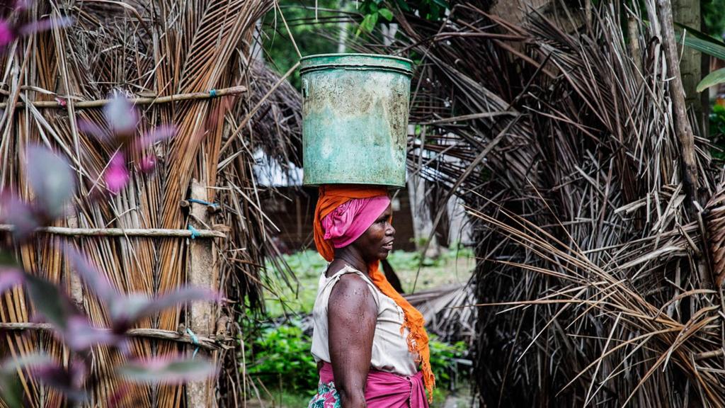 This picture taken on April 29, 2019 shows a woman carrying a bucket containing water collected from the Haikata well which was built in 1545 by African slaves and never been dried since then in Mikindani, southern Tanzania