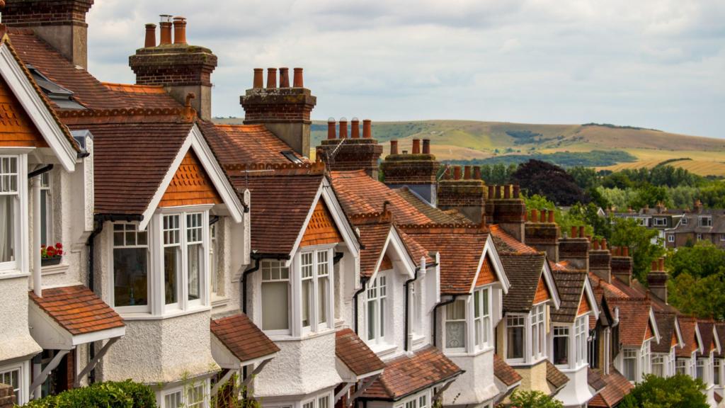 Rows of houses with hills visible behind