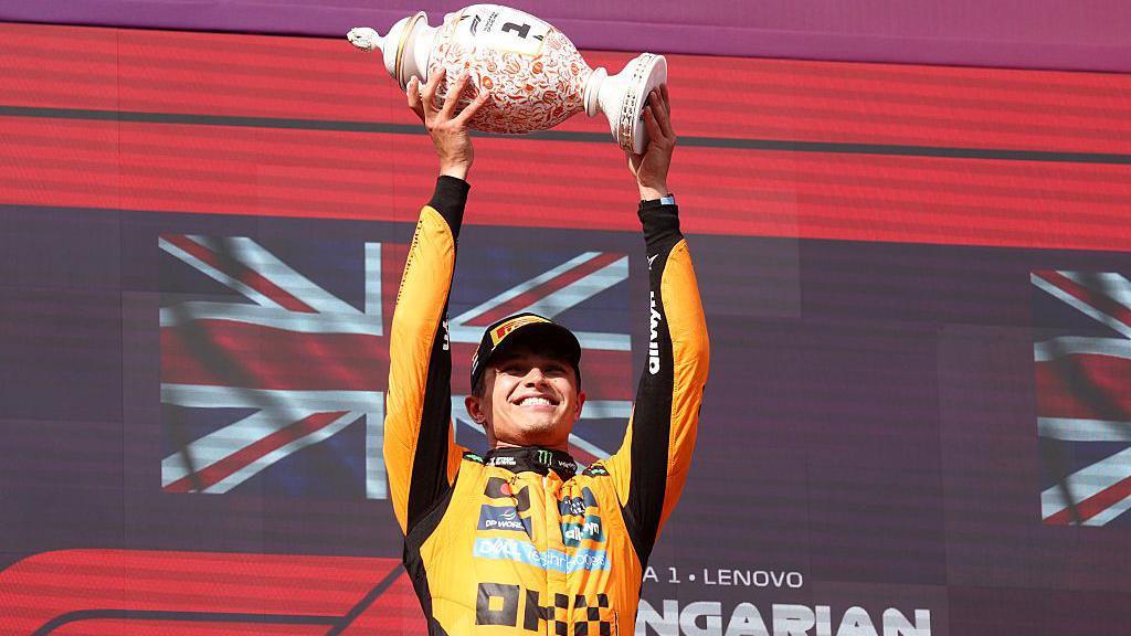 Lando Norris lifts the winner's trophy in Hungary 