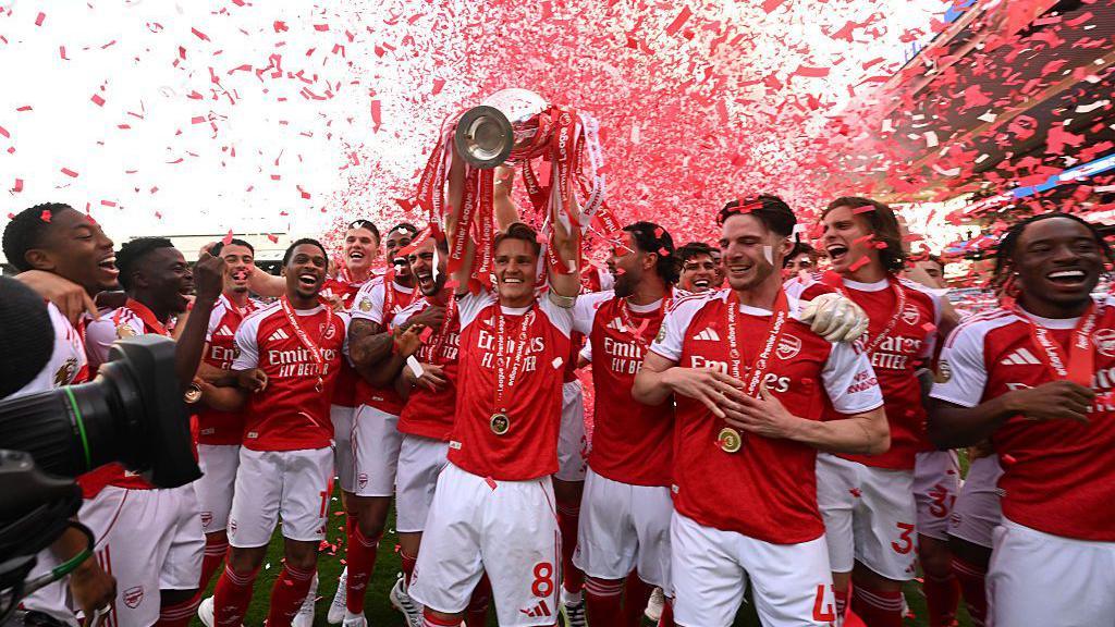 Arsenal captain Martin Odegaard lifts the Premier League trophy.