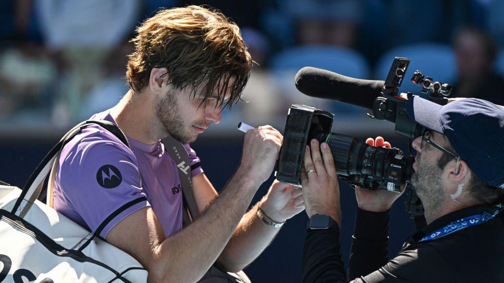 Taylor Fritz writes a message on a video camera lens after winning against Chile's Cristian Garin