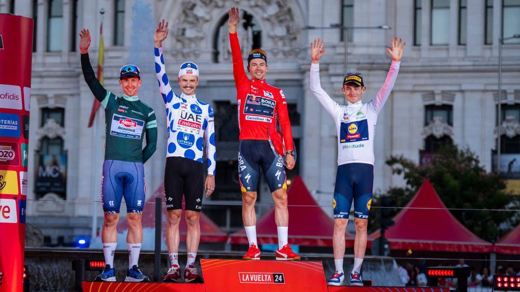 From left to right: Kaden Groves in the green jersey, Jay Vine in the polka-dot jersey, Primoz Roglic in the red jersey and Mattias Skjelmose in the white jersey on the podium at the 2024 Vuelta a Espana