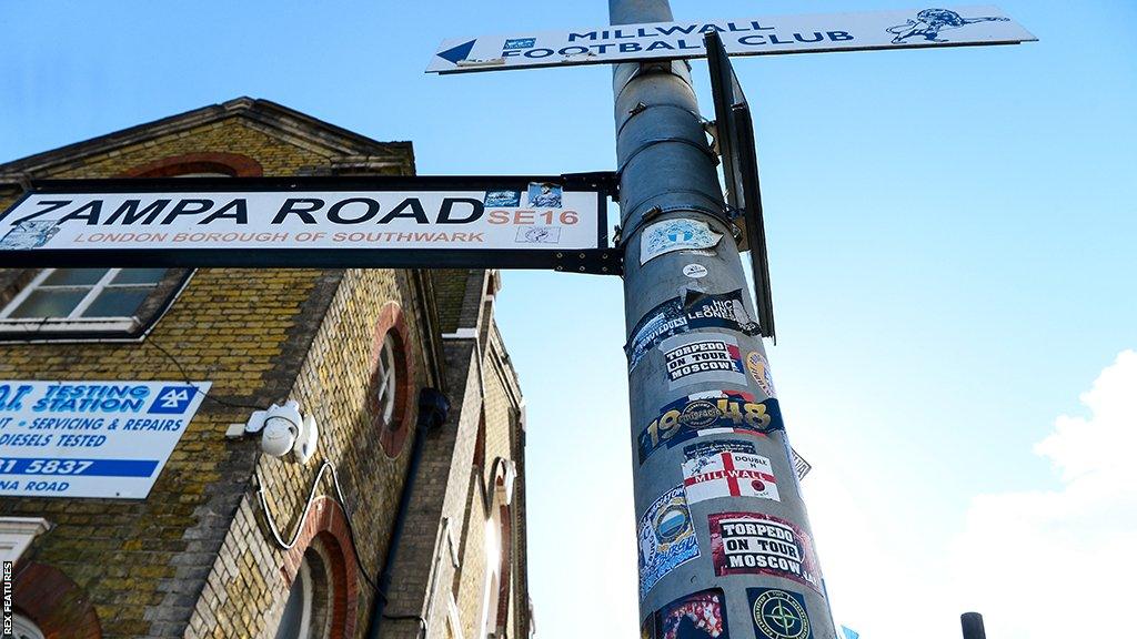 Street signs showing Zampa Road and pointing towards Millwall Football Club