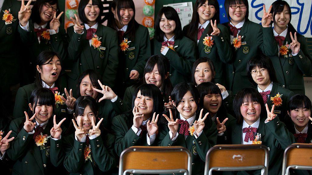 Japanese students holding up the peace sign.