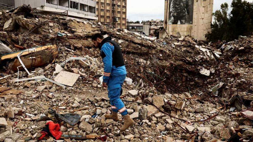 A paramedic walks among the rubble at a site damaged in an Israeli strike, amid escalating hostilities between Israel and Hezbollah, as the U.S.-Israeli conflict with Iran continues, in Nabatieh, Lebanon, March 25, 2026.