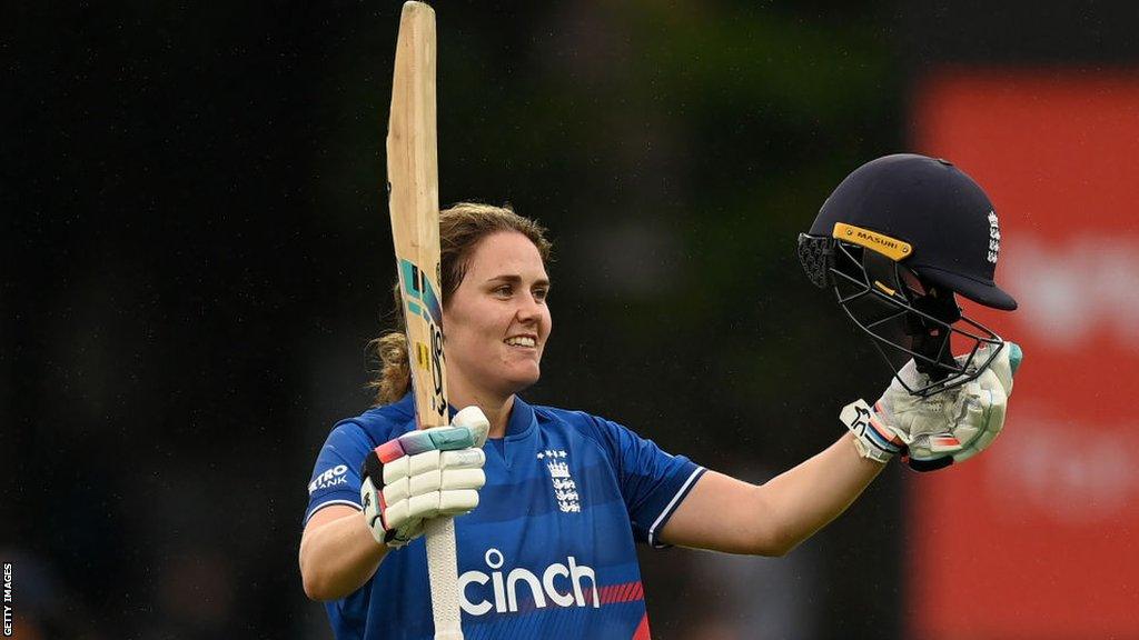 Nat Sciver-Brunt lifts her helmet and bat in celebration