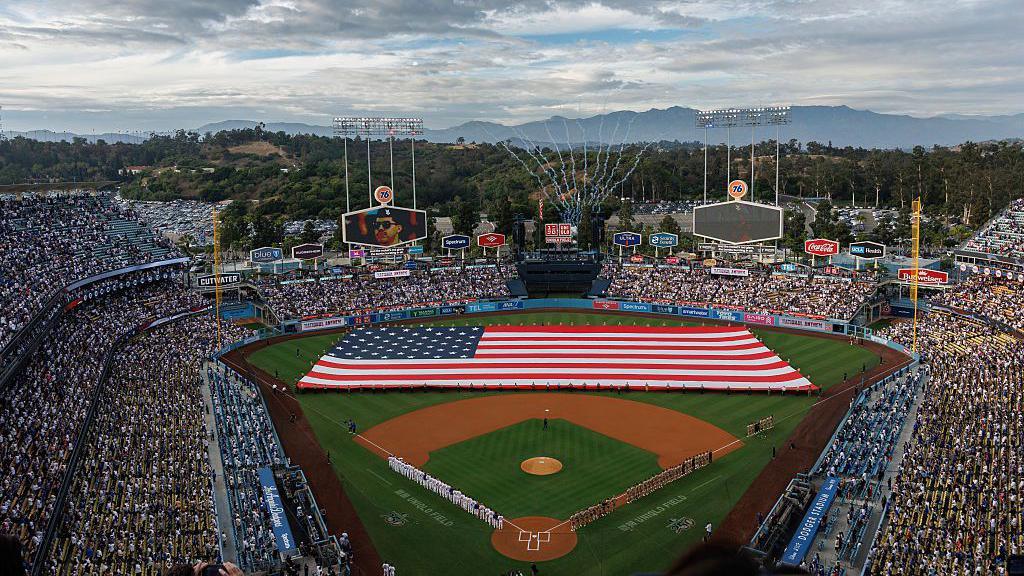 A giant American flag on the baseball field during the game between the LA Dodgers and San Diego Padres at Dodger Stadium in Los Angeles.