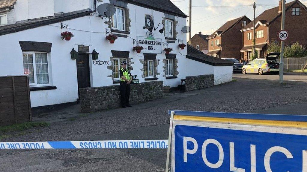 A police officer in front of a pub