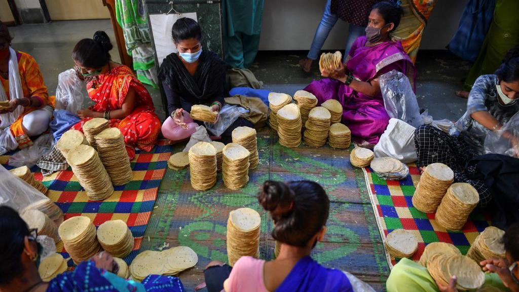 In this photograph taken on March 8, 2021, members of Shri Mahila Griha Udyog, the organisation that produces the famous Lijjat Papad, arrange rolled papadums for delivery at one of the organisation's facilities in Mumbai. - The fairytale success of Lijjat Papad -- a multi-million-dollar venture founded by seven women in a crowded Mumbai tenement in 1959 with seed capital of 80 rupees (1.10 USD) -- belies its revolutionary feminist aspirations. - TO GO WITH India-economy-gender-food, FEATURE by Ammu KANNAMPILLY (Photo by Indranil MUKHERJEE / AFP) / TO GO WITH India-economy-gender-food, FEATURE by Ammu KANNAMPILLY (Photo by INDRANIL MUKHERJEE/AFP via Getty Images)
