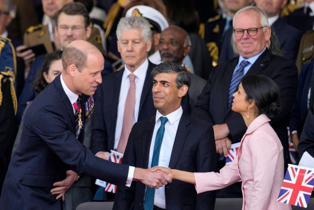 Prince William shakes hands with Akshata Murty while Prime Minister Rishi Sunak looks on