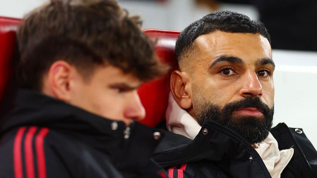 Mohamed Salah (R) looks on from the substitute's bench