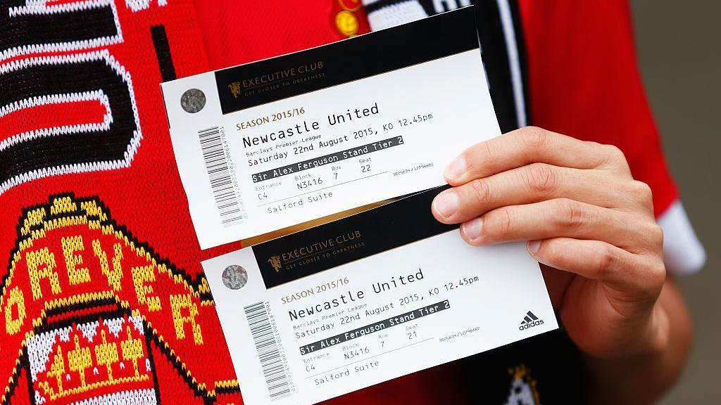 A supporter holding two tickets for Manchester United against Newcastle United