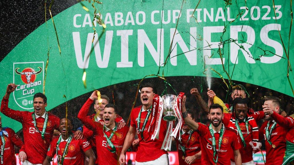 Manchester United players celebrate with the Carabao Cup trophy at Wembley