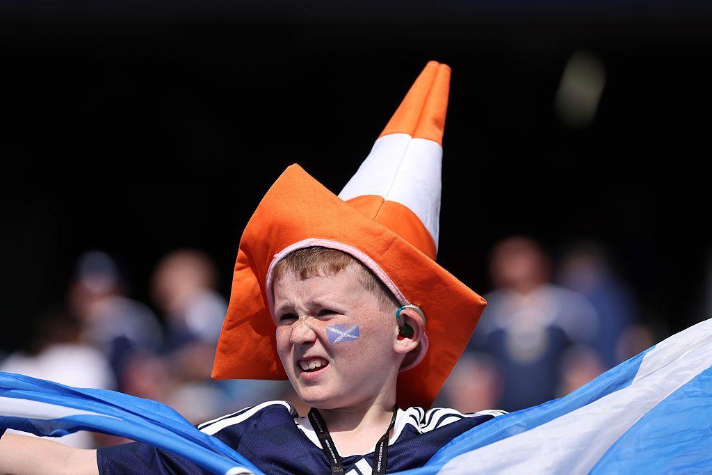 A young Scotland fan wearing a traffic cone hat.