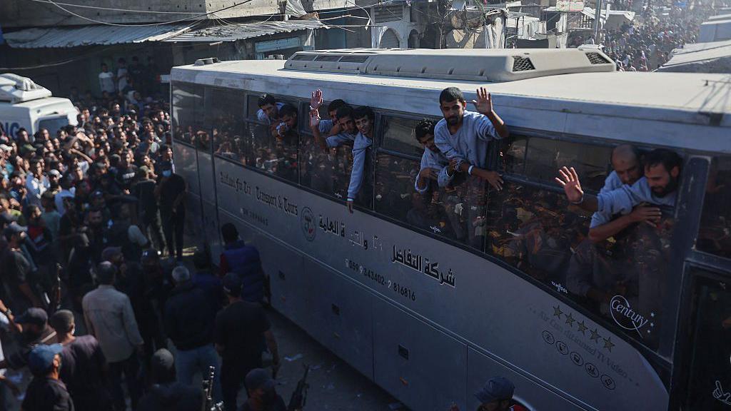 Freed palestinians wave at crowds in Khan Younis. 