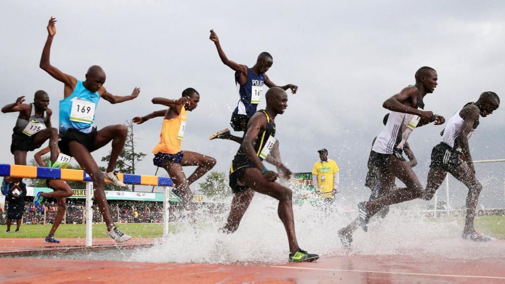 Athletes jumping over a hurdle