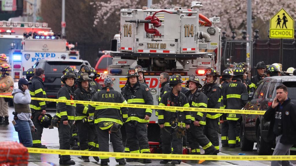 New York City Police and Fire Department officials on the scene of a reported multiple shooting at a New York City Subway station in the Brooklyn borough of New York, New York, USA, 12 April 2022