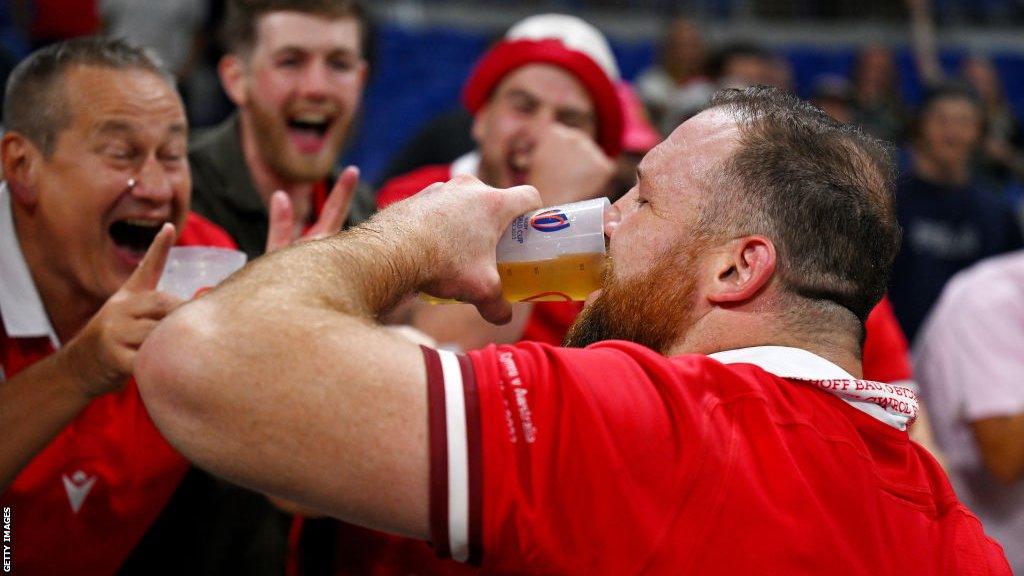 Henry Thomas drinking beer with fans